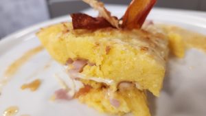 Una forma deliciosa de preparar una flor de polenta: En capas con salsa casera, queso y jamón