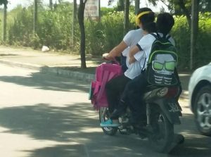 Imprudencia: Conduce una moto, con tres niños, sin casco y los auriculares puestos