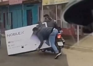 Video: a un argentino se le cayó un televisor de 65 pulgadas de la moto y lo buscan por las redes